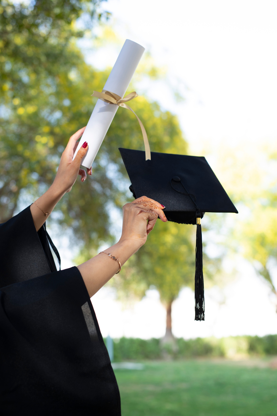 Student Holding Diploma and Graduation Hat